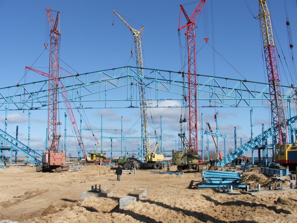 Четыре крана держат фермы пролетом 72, пятый кран устанавливает прогоны.