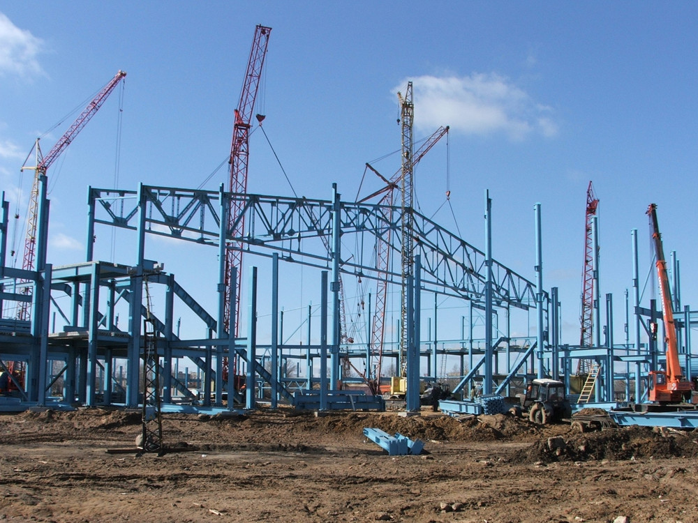 Четыре крана держат фермы пролетом 72, пятый кран устанавливает прогоны.