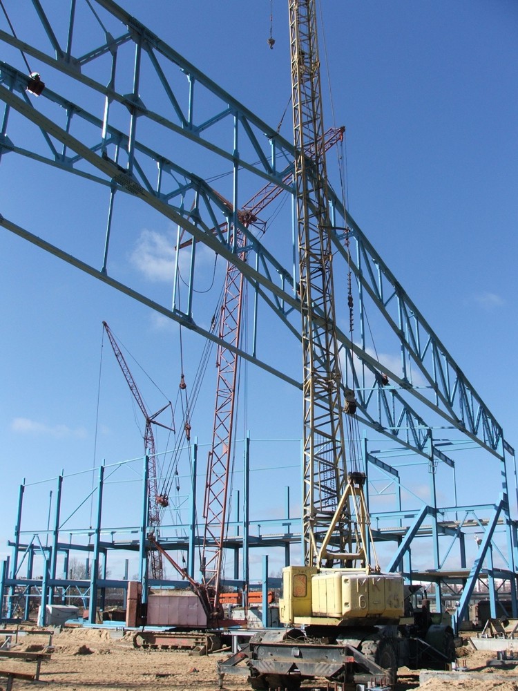 Четыре крана держат фермы пролетом 72, пятый кран устанавливает прогоны.
