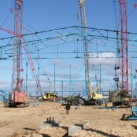 Четыре крана держат фермы пролетом 72, пятый кран устанавливает прогоны.