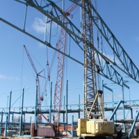 Четыре крана держат фермы пролетом 72, пятый кран устанавливает прогоны.